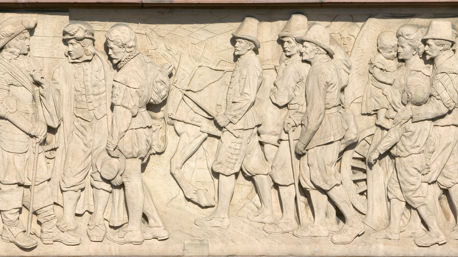 Detailliertes Relief, das die Ankunft wallonischer Flüchtlinge in Mannheim zeigt.