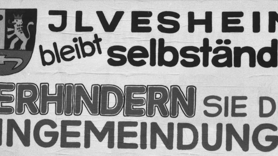 schwarz-weiß Foto eines Großplakats am Ortseingang von Ilvesheim, auf dem geschrieben steht: "Ilvesheim bleibt selbstständig. Verhindern Sie die Eingemeindung. Wählen Sie am 17. Juni ja", 1973