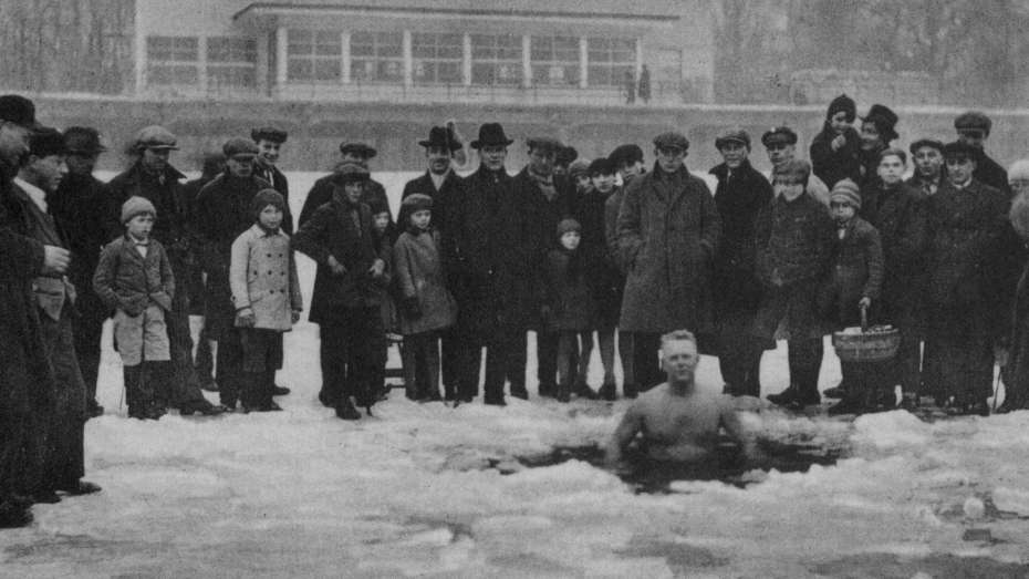 schwarz-weiß Foto eines Mannes, der am 18.Februar 1929 bei minus 16 Grad im Rhein badet und von einer Menschenmenge umgeben ist