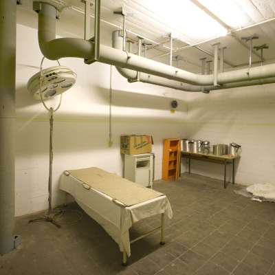 Luftschutzbunker des Zweiten Weltkriegs waren kleinräumig unterteilt und wiesen eine Vielzahl von Nebenräumen auf. Hier ein ärztliches Behandlungszimmer mit Operationstisch und –leuchte. MARCHIVUM, Signatur AB02080-002. Foto: Sarah Hähnle-Balastegui, 2008.