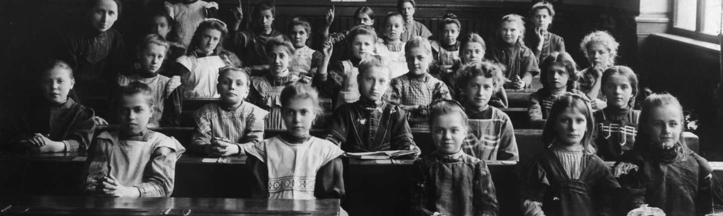 schwarz-weiß Foto, Blick in ein historisches Klassenzimmer mit Schülerinnen