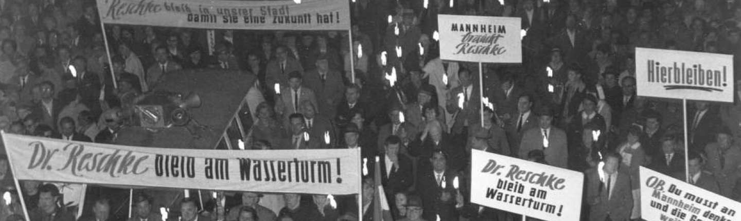 schwarz-weiß Foto einer Menschenmenge und Spruchbannern vom Fackelzug für OB Hans Reschke,11. Mai 1962 