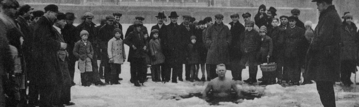 schwarz-weiß Foto eines Mannes, der am 18.Februar 1929 bei minus 16 Grad im Rhein badet und von einer Menschenmenge umgeben ist