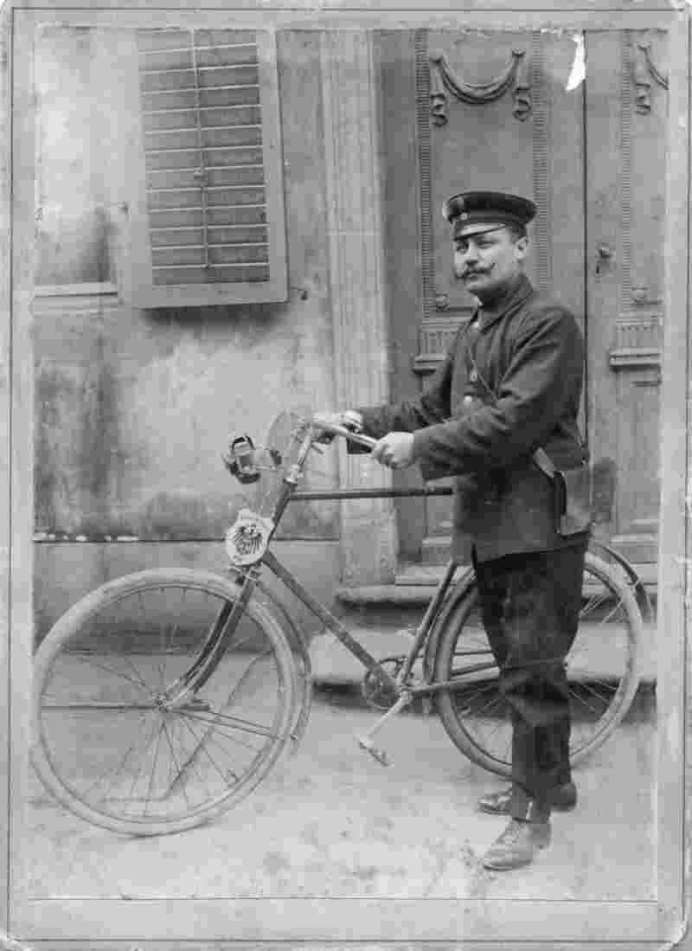 Postbote mit Fahrrad, um 1900.